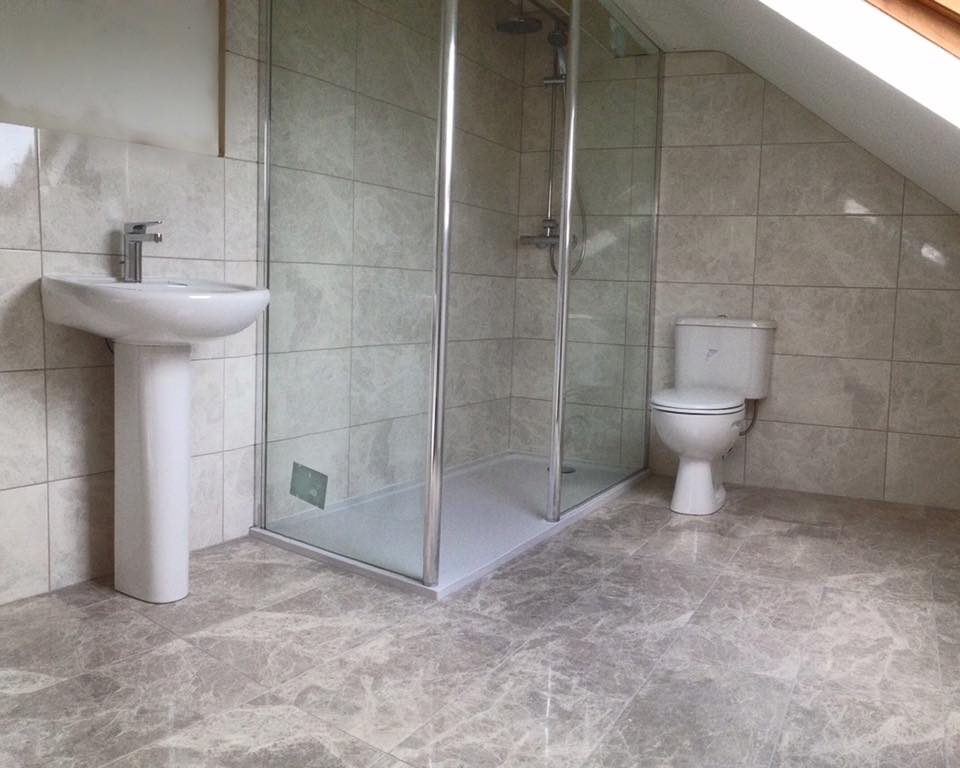 Shower, toilet and sink with floor and wall tiling